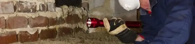 Pest control technician inspecting a crawl space for ant activity and entry points in Albuquerque, NM