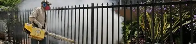 Mosquito control technician fogging a yard perimeter for mosquito reduction in Albuquerque, NM
